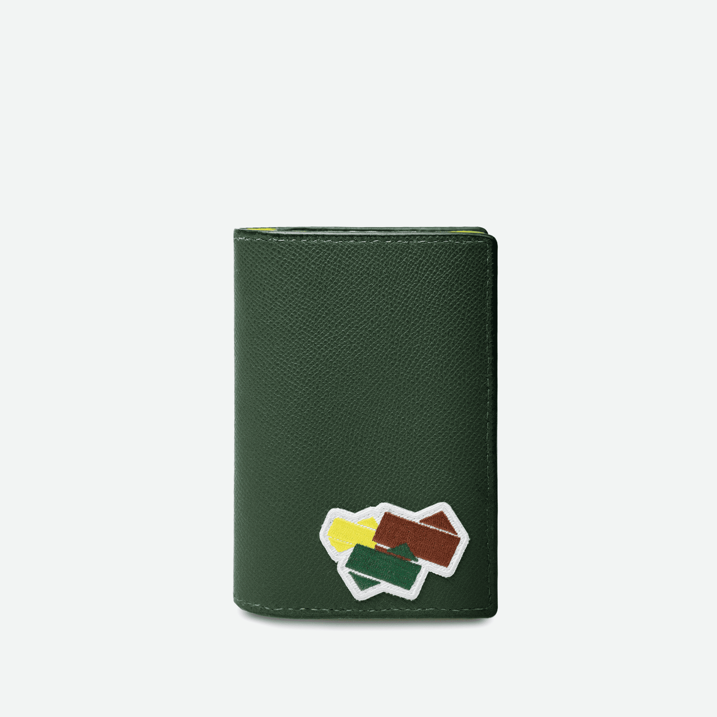 Couverture de passeport en cuir grainé de la collection Tennis. Logo brodé sur un patch à l'avant de la petite maroquinerie. 