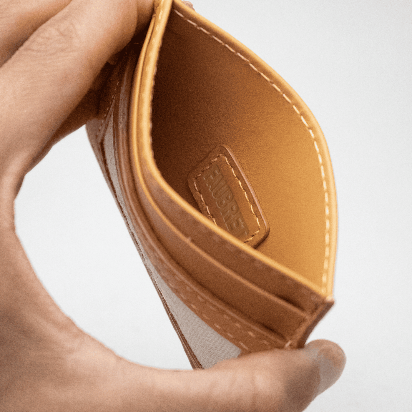 étiquette cousu avec du fils de lin en tons sur tons, avec l'inscription embossé sur le cuir Faubret