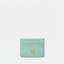 Porte-cartes de crédit en cuir menthe orné d’un logo doré géométrique, combinant élégance contemporaine et savoir-faire artisanal.