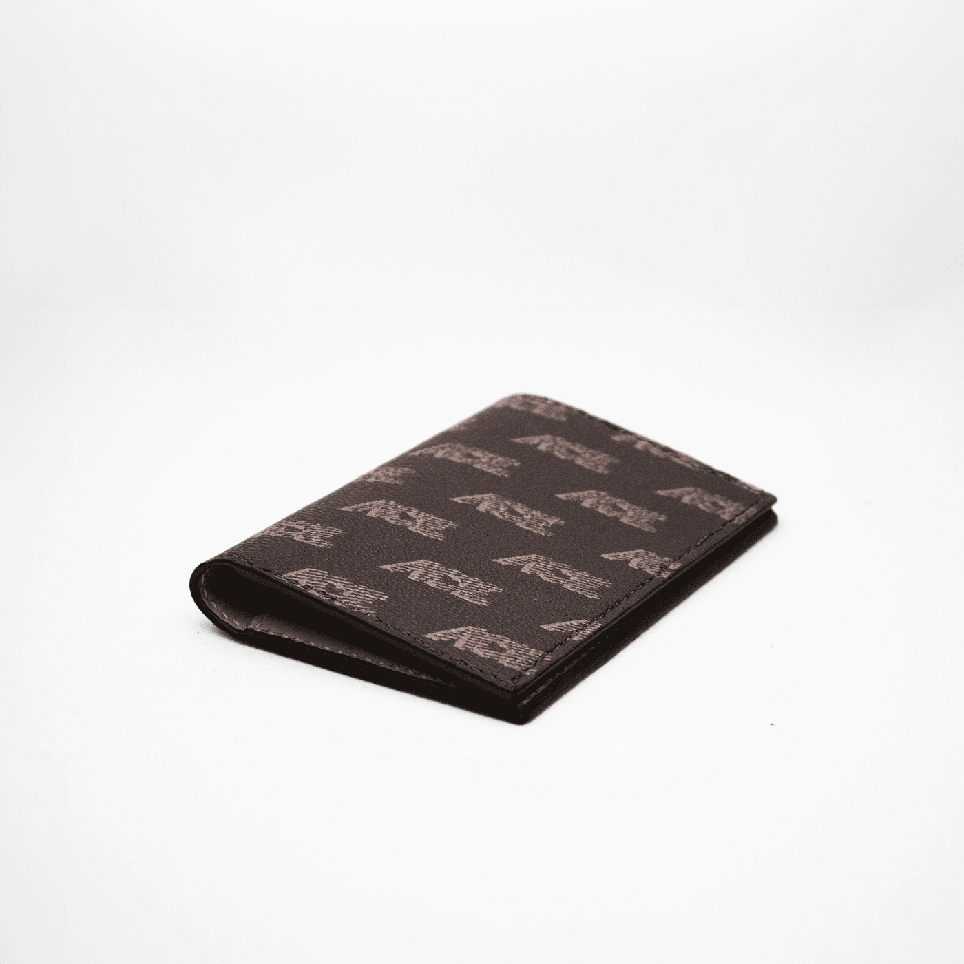 Protège passeport en toile marron et imprimé sur fond blanc à plat