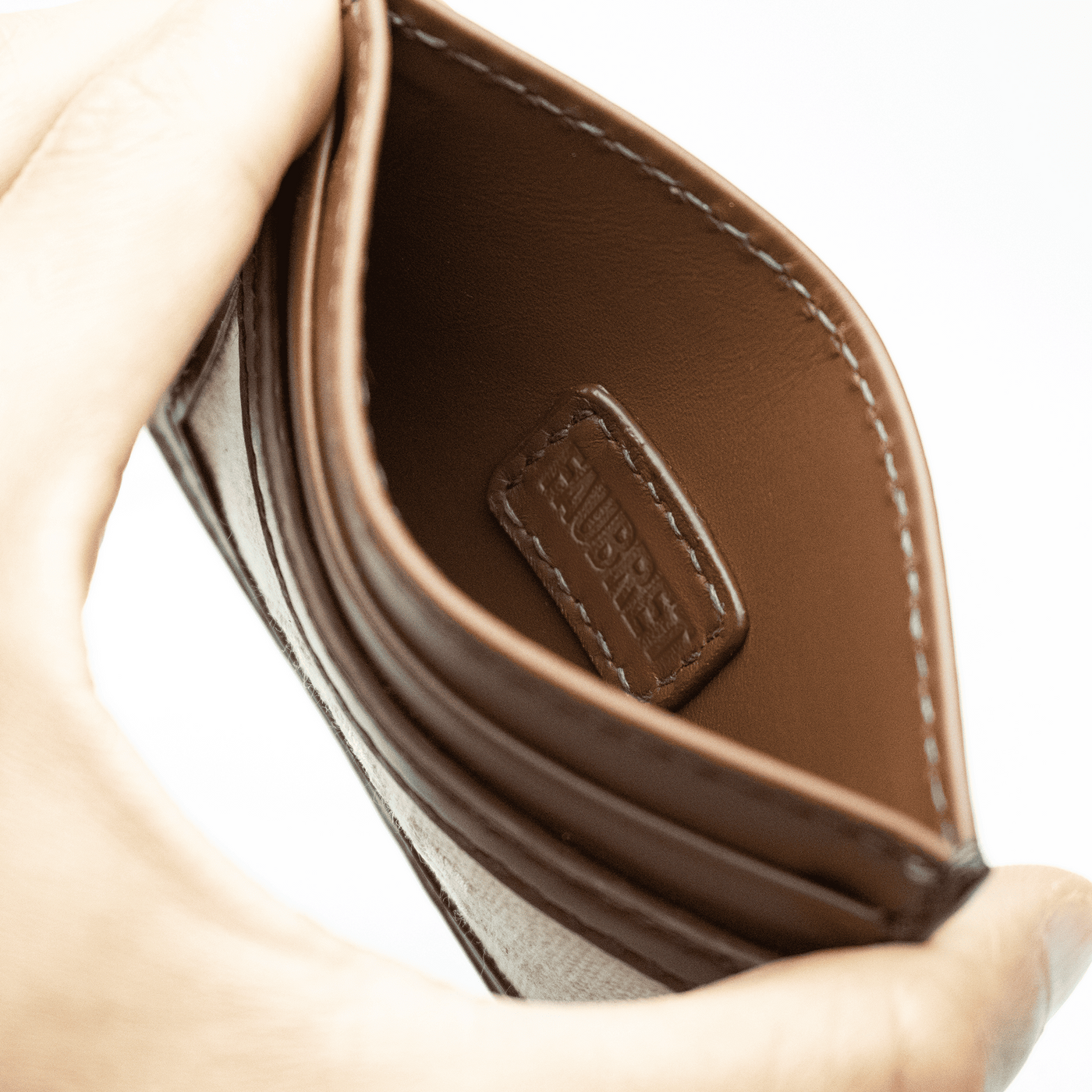 Poche centrale sur laquelle est cousu l'étiquette Faubret embossé sur cuir.