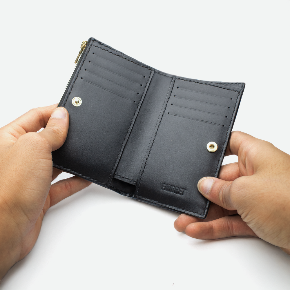 Intérieur du porte-carte femme FAUBRET en cuir noir avec emplacements pour cartes et bouton pression.