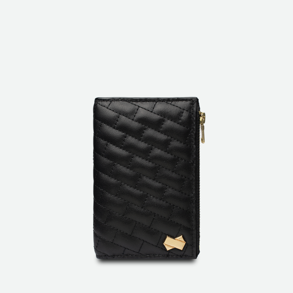 Porte-carte femme FAUBRET en cuir noir matelassé vu de face avec logo doré et fermeture zippée sur le côté