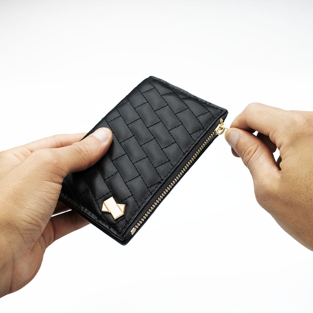 Porte-carte femme FAUBRET tenu à la main avec ouverture de la fermeture zippée montrant le format compact