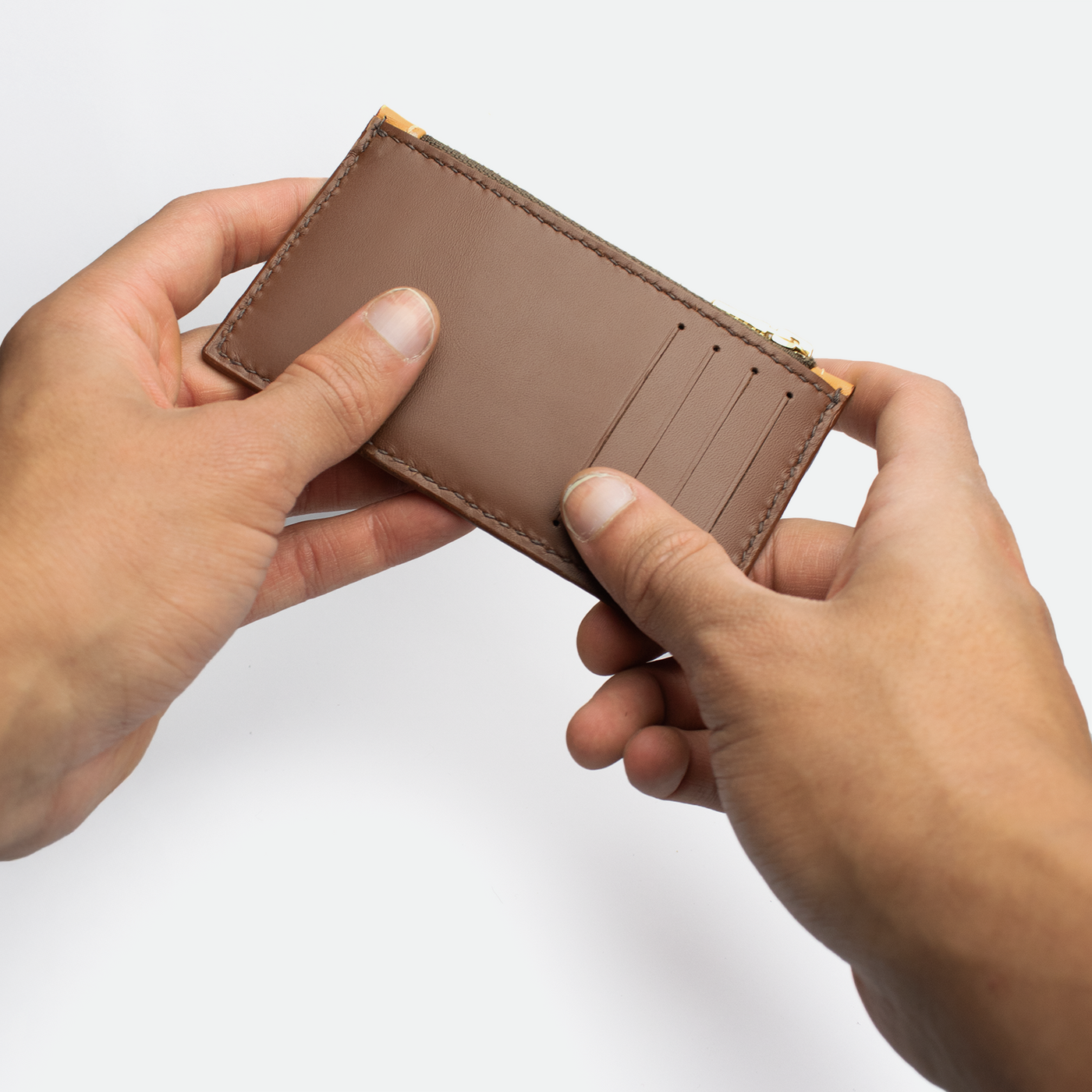 Porte monnaie cartes femme Faubret en cuir bicolore caramel et marron, format fin et compact illustrant une prise en main élégante au quotidien.