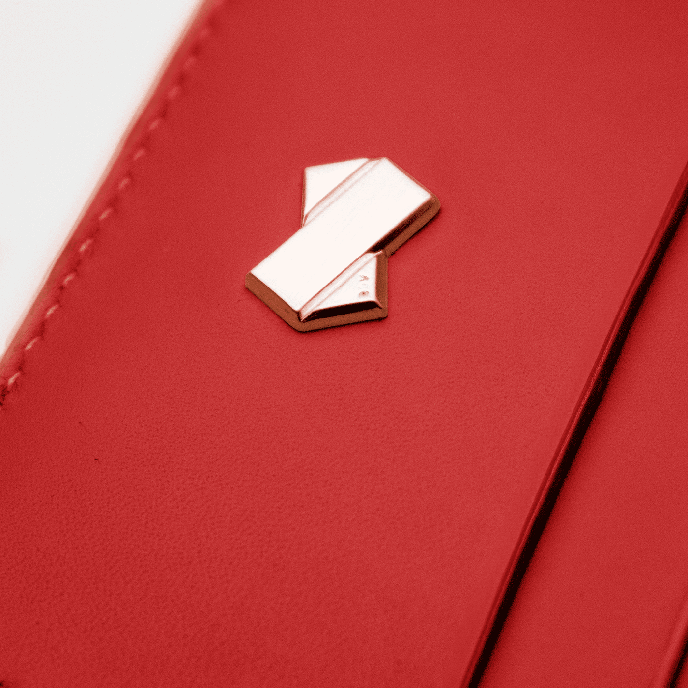 Logo doré Ace Paris sur la tranche avant du porte-cartes rouge